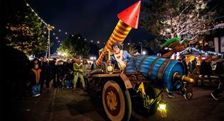 Personnages Efteling Max et Moritz sont assis sur un char coloré avec une grande fusée de feu d’artifice.